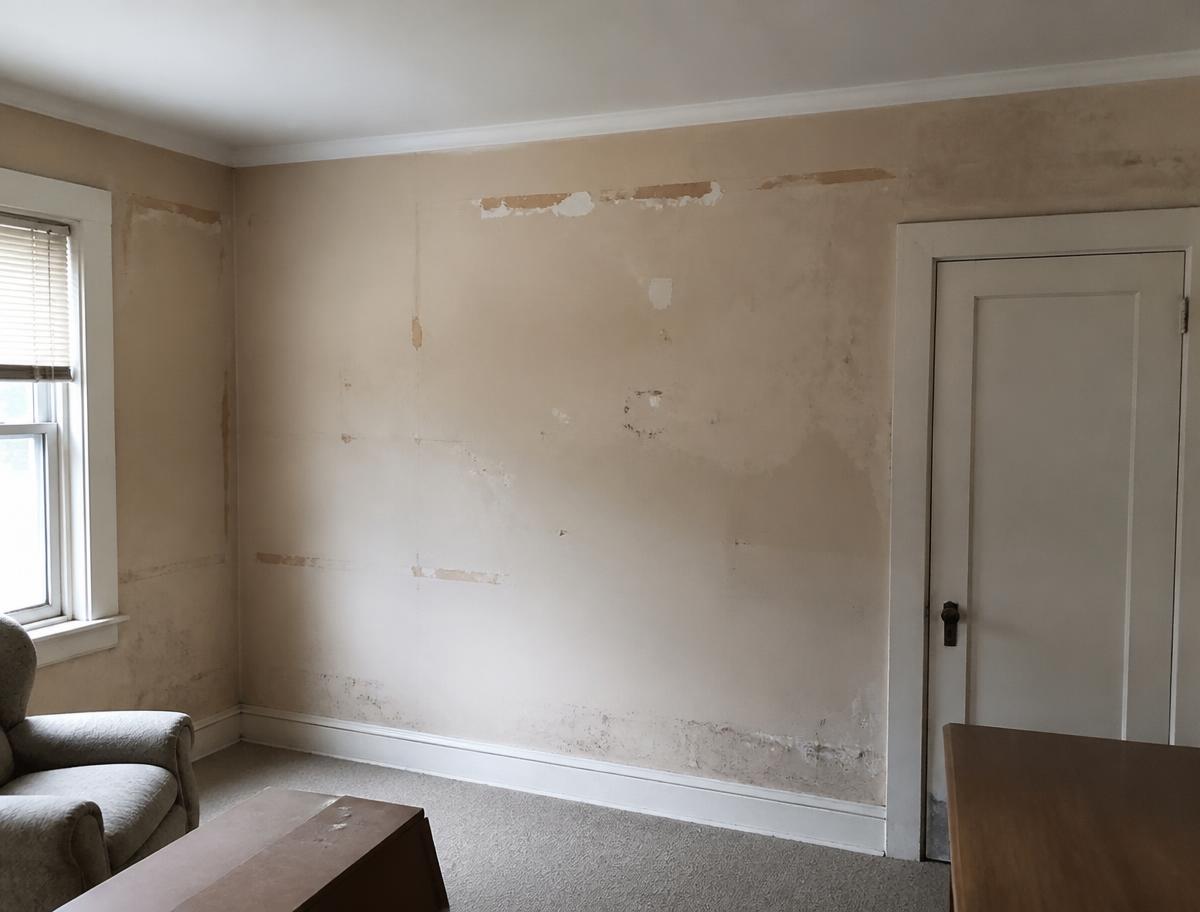 Stained scuffed interior walls with peeling paint before repainting